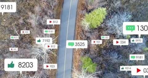Aerial drone view of winding road through autumn forest with floating social media icons