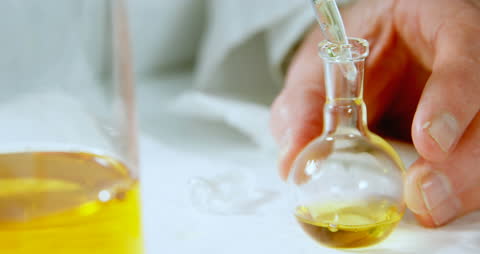Scientist Pouring Liquid into Laboratory Flask for Experiment