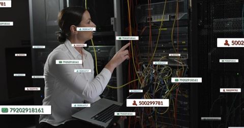 IT technician troubleshooting server rack with laptop, organizing network cables