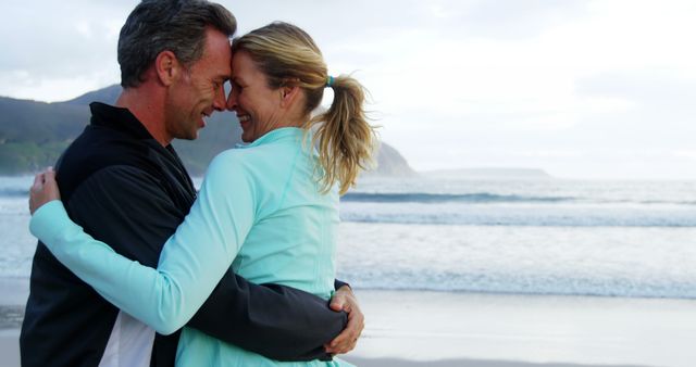 Middle-aged couple embracing on beach during sunset - Download Free Stock Images Pikwizard.com