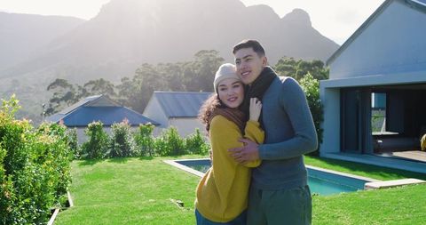 Couple Embracing by Modern Home with Mountain View