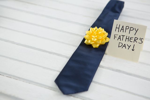 High angle view of happy fathers day text by necktie on white table