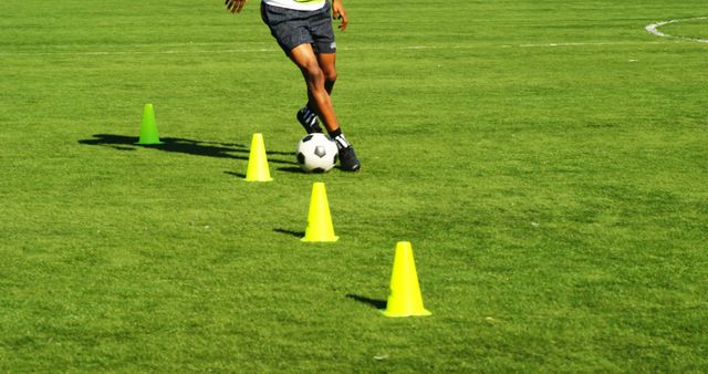 Football Player Dribbling Ball Through Training Cones On Green Field - Download Free Stock Images Pikwizard.com