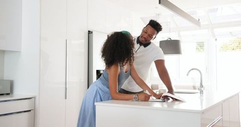 Happy Couple Planning Recipes in Modern Kitchen