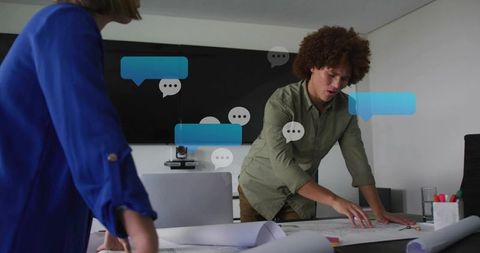 Collaborating architects reviewing blueprints in modern boardroom with chat overlays