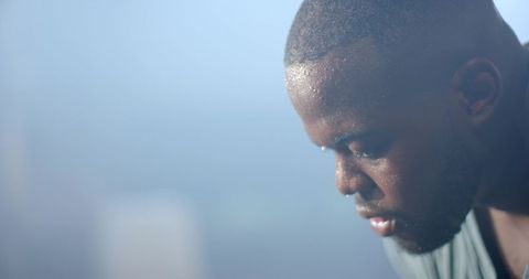 African american athlete leaning forward sweating post-workout closeup portrait