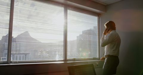 Male Executive Talking on Phone in Sunlit Office Room - Download Free Stock Images Pikwizard.com