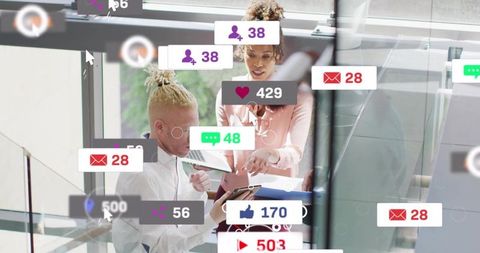 Reviewing social metrics and collaborating on devices in modern glass office