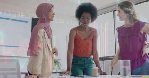 Diverse businesswomen analyzing digital financial data in office