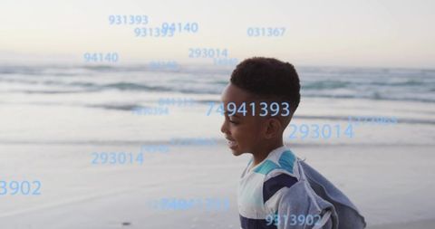 Smiling child running along beach with floating blue numeric overlay and ocean horizon