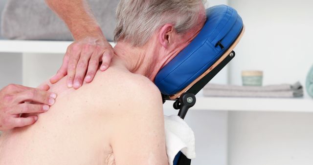 Senior man receiving a therapeutic shoulder and back massage, showcasing importance of wellness and healthcare for elderly. Ideal for articles or materials focusing on senior healthcare, physiotherapy, muscle pain relief, and relaxation. Useful for promoting wellness services, massage therapists, and spa treatments.