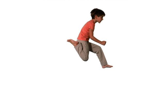 Youthful boy caught mid-air while jumping against a white background. This dynamic image captures the energy and joy of childhood. Ideal for advertisements, inspirational posters, educational materials, or any content emphasizing activity, youth, or motion. The neutral background makes it easy to isolate the subject for various creative uses.