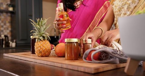 Indian Mother and Daughter Unpacking Groceries in Kitchen