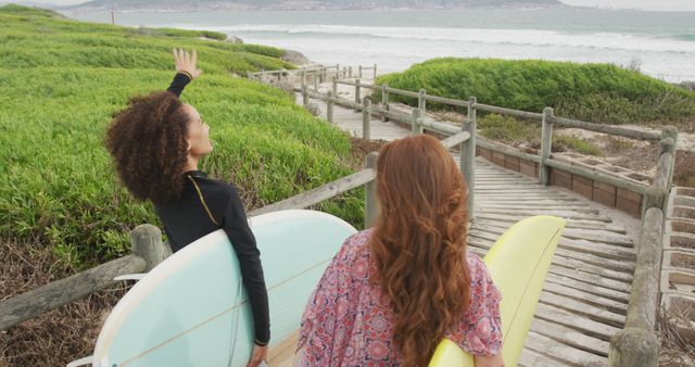 Two Women Carrying Surfboards and Heading Towards the Ocean - Download Free Stock Images Pikwizard.com