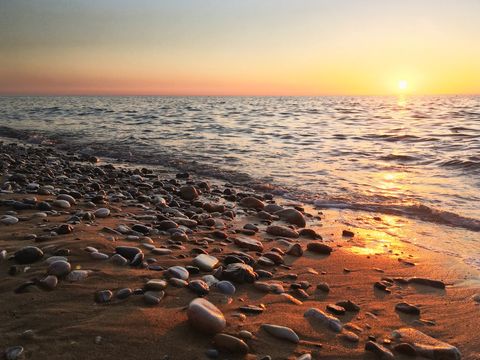 Cover background peaceful sunset over sandy pebble beach