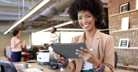 Confident Businesswoman Holding Tablet in Modern Collaborative Office