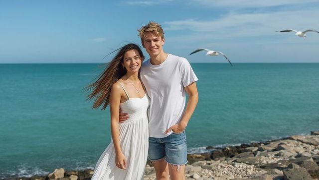 Couple enjoying sunny day on rocky beach by turquoise sea