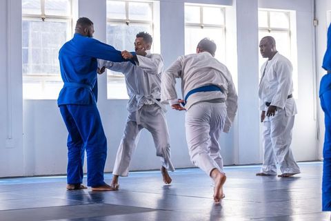 Diverse Martial Arts Class Practicing Judo in Training Room