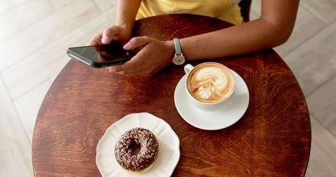 Casual Cafe Ambiance with Coffee, Doughnut, and Smartphone