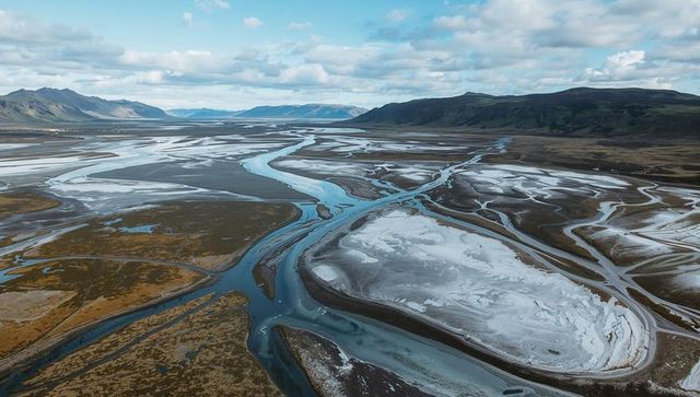 Breathtaking aerial view of braided river valley with distant peaks