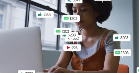 Content creator typing on laptop with floating social media notifications and analytics