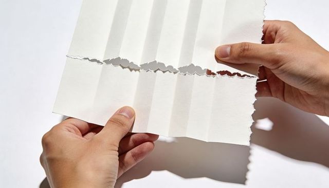 Hands Tearing Folded White Paper with Jagged Edge Minimal Monochrome Concept