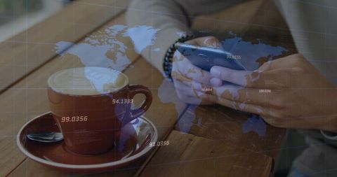 Man tapping smartphone at cafe table with coffee cup and global data overlay