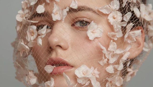 Dewy beauty portrait wearing floral veil netting with delicate petal details