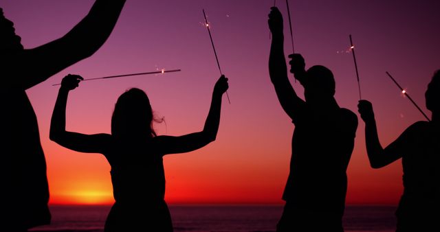 Group Celebrating at Sunset with Sparklers on Beach - Download Free Stock Images Pikwizard.com