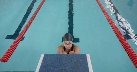 Competitive swimmer preparing for race in indoor pool