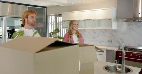 Happy Couple Touring New Home Kitchen Smiling and Embracing