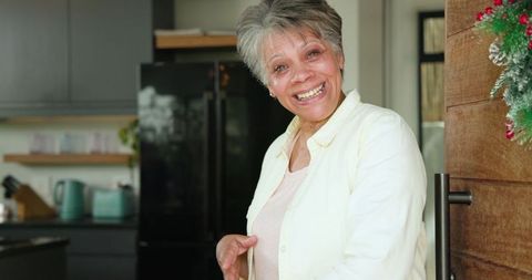 Senior Woman Smiling in Cozy Kitchen with Wooden Door
