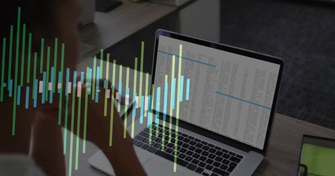Blurred office desk and businesswoman with spreadsheet on laptop
