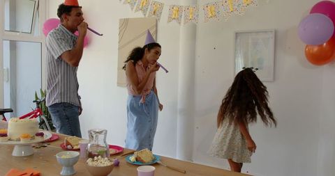 Family birthday celebration with hats and cake at home