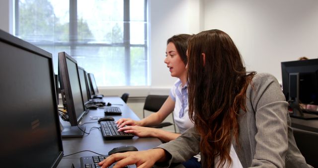 Two Women Collaborating on Computers in Office Setting - Download Free Stock Images Pikwizard.com