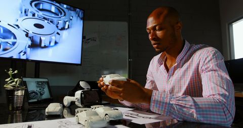 Executive analyzing car prototype in modern office environment