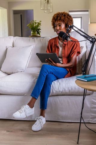 African american creator recording podcast at home with tablet and professional microphone