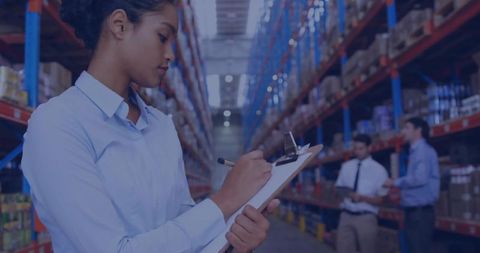Warehouse inventory supervisor checking stock on clipboard in high-rack distribution aisle