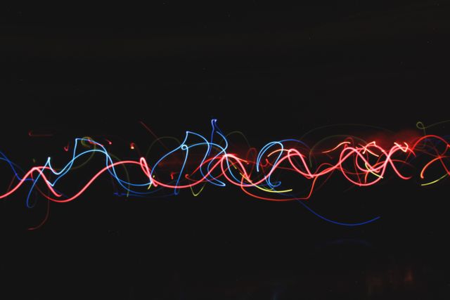 This image showcases abstract neon light streaks on a dark background, creating vibrant and colorful patterns. It is great for backgrounds, digital artwork, or designs that require an energetic and dynamic visual element. Perfect for creative projects, presentations, or advertisements involving technology, nightlife, or entertainment themes.