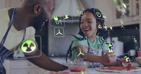 Father and daughter cooking together with eco-friendly symbols