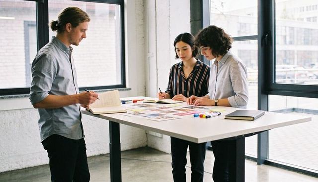 Design team collaborating over moodboard and color swatches in bright loft workspace