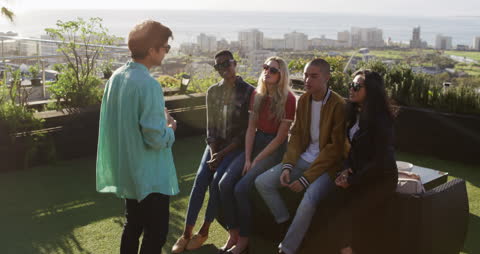 Friends Socializing on Rooftop with Ocean View