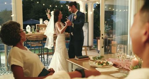 Bride and groom joyfully dancing at intimate wedding reception