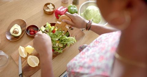 Woman Preparing Fresh Salad in Cozy Home Kitchen