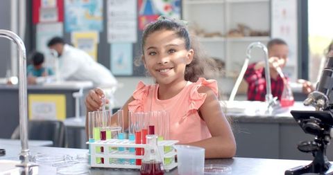 Young biracial girl conducting science experiment in laboratory