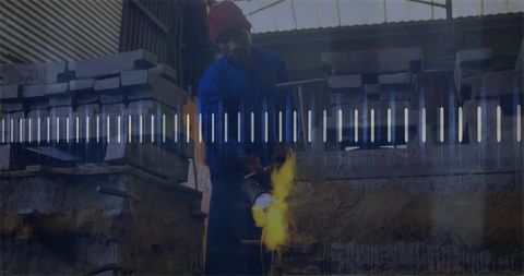 Foundry worker pouring molten metal in industrial workshop