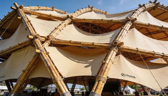 Bamboo lattice pavilion featuring tensile beige canopy, rope rigging and hexagonal frame