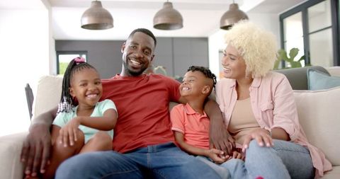 Joyful African American Family Relaxing on Cozy Home Couch