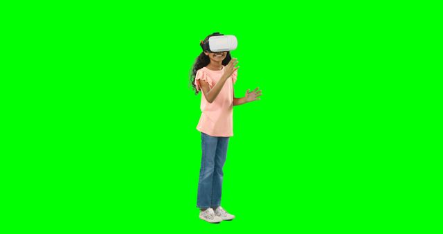 Young girl wearing VR headset, exploring virtual reality against green screen background. Ideal for educational content, technology demonstrations, and presentations on VR and digital innovation. Can be used to depict futuristic learning, immersive gaming, or interactive entertainment scenarios.