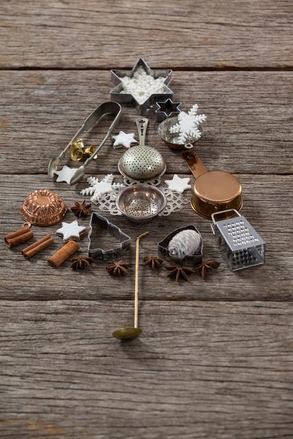 Creative arrangement of kitchen utensils and decorations forming a Christmas tree on a wooden background. Ideal for holiday-themed projects, DIY inspiration, festive greeting cards, and seasonal blog posts.